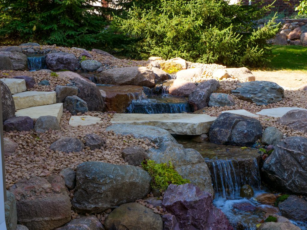 Close view of the award-winning Ankeny pondless waterfall and slab bridge