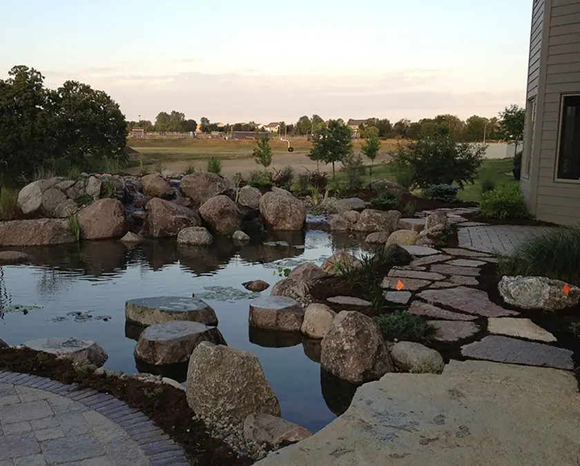 Finished backyard pond with a boulder waterfall