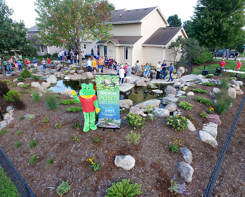 Visitors gathered around a backyard pond during a Just Add Water pond tour