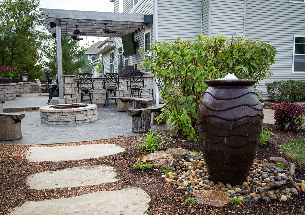 Bubbling urn fountain set in a landscaped garden bed