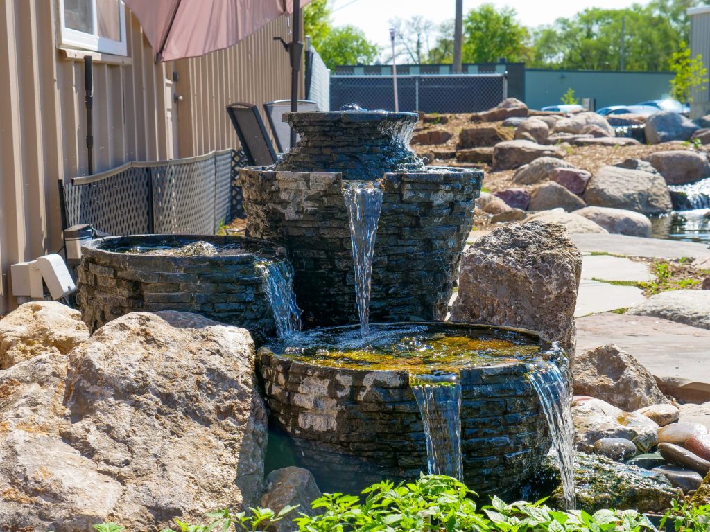 Stacked stone urn fountains spilling into a rock basin at the Just Add Water office