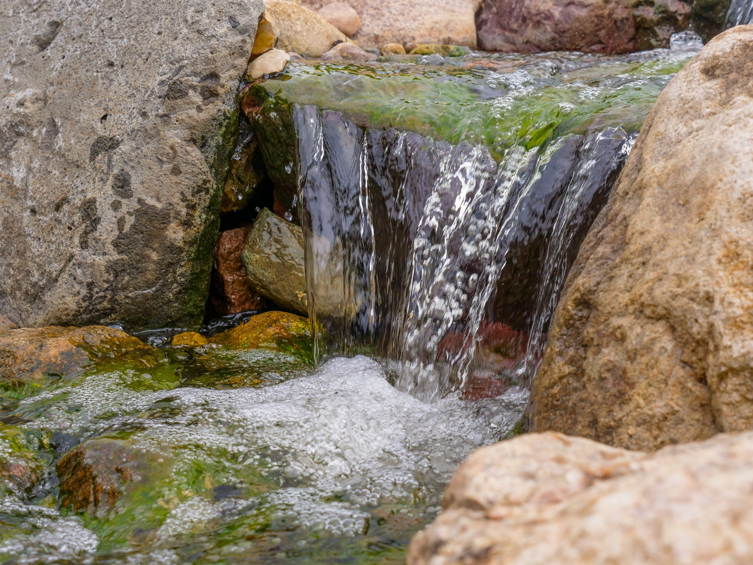 Natural stone waterfall flowing into the pond