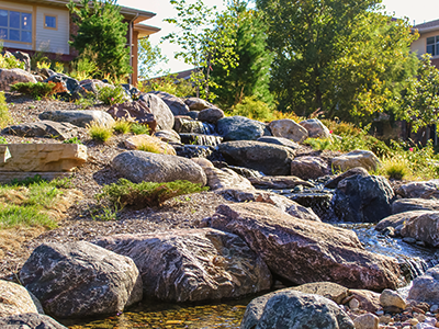Long pondless stream with several waterfalls flowing through large boulders