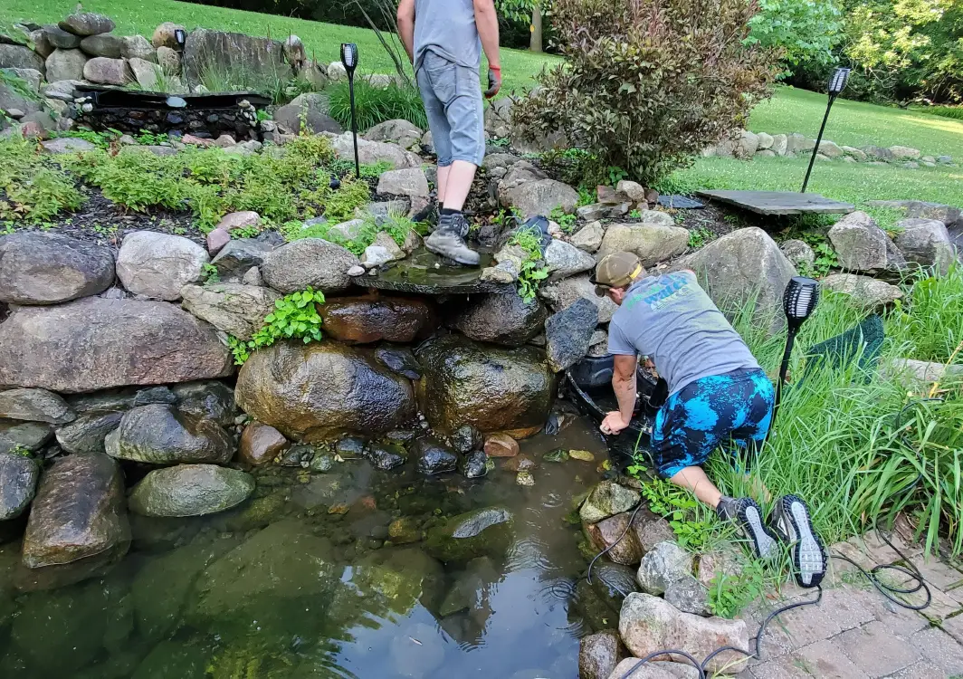 Just Add Water crew cleaning out a drained pond by hand