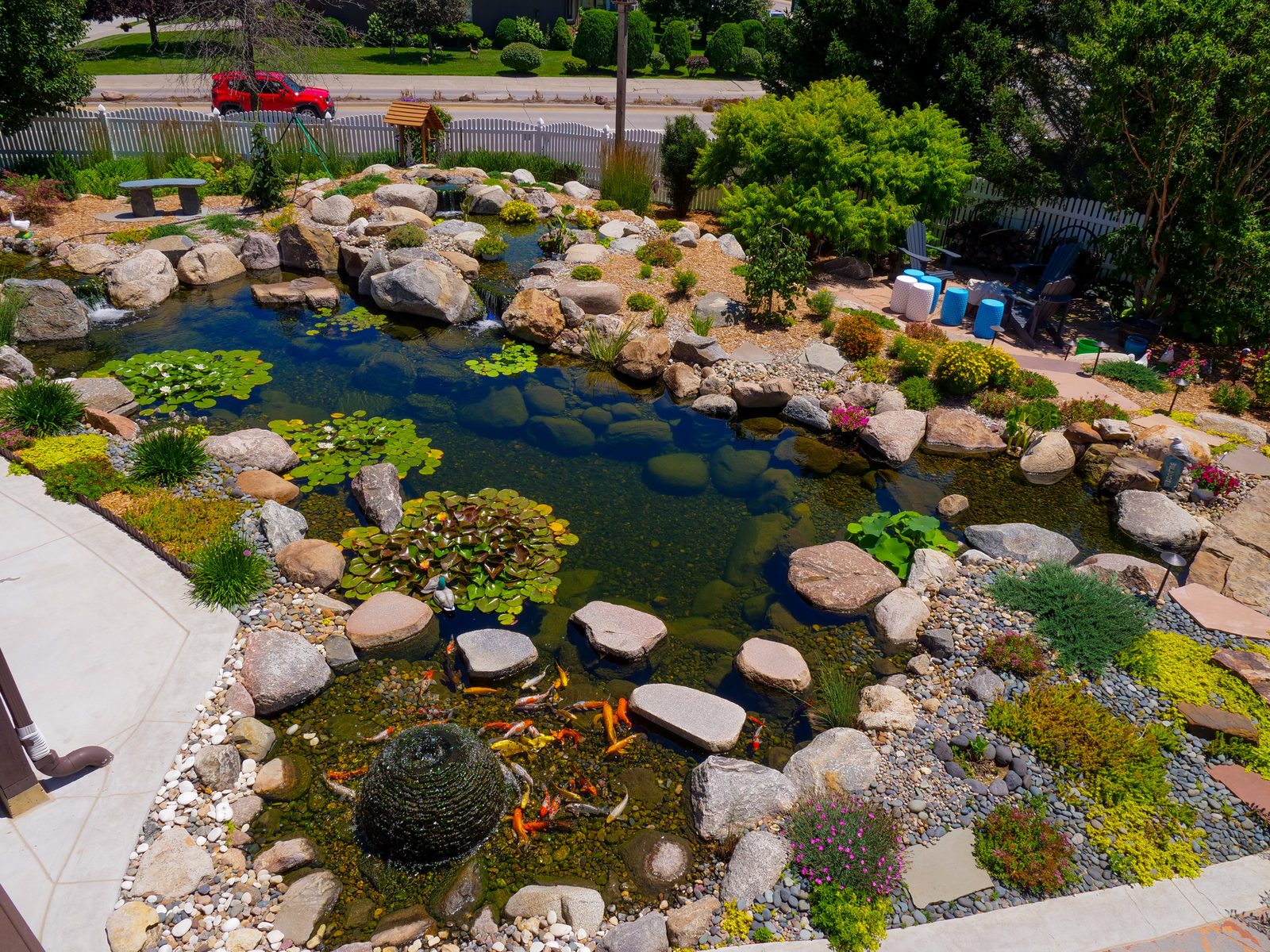 Aerial view of an ecosystem pond with a patio and gravel border